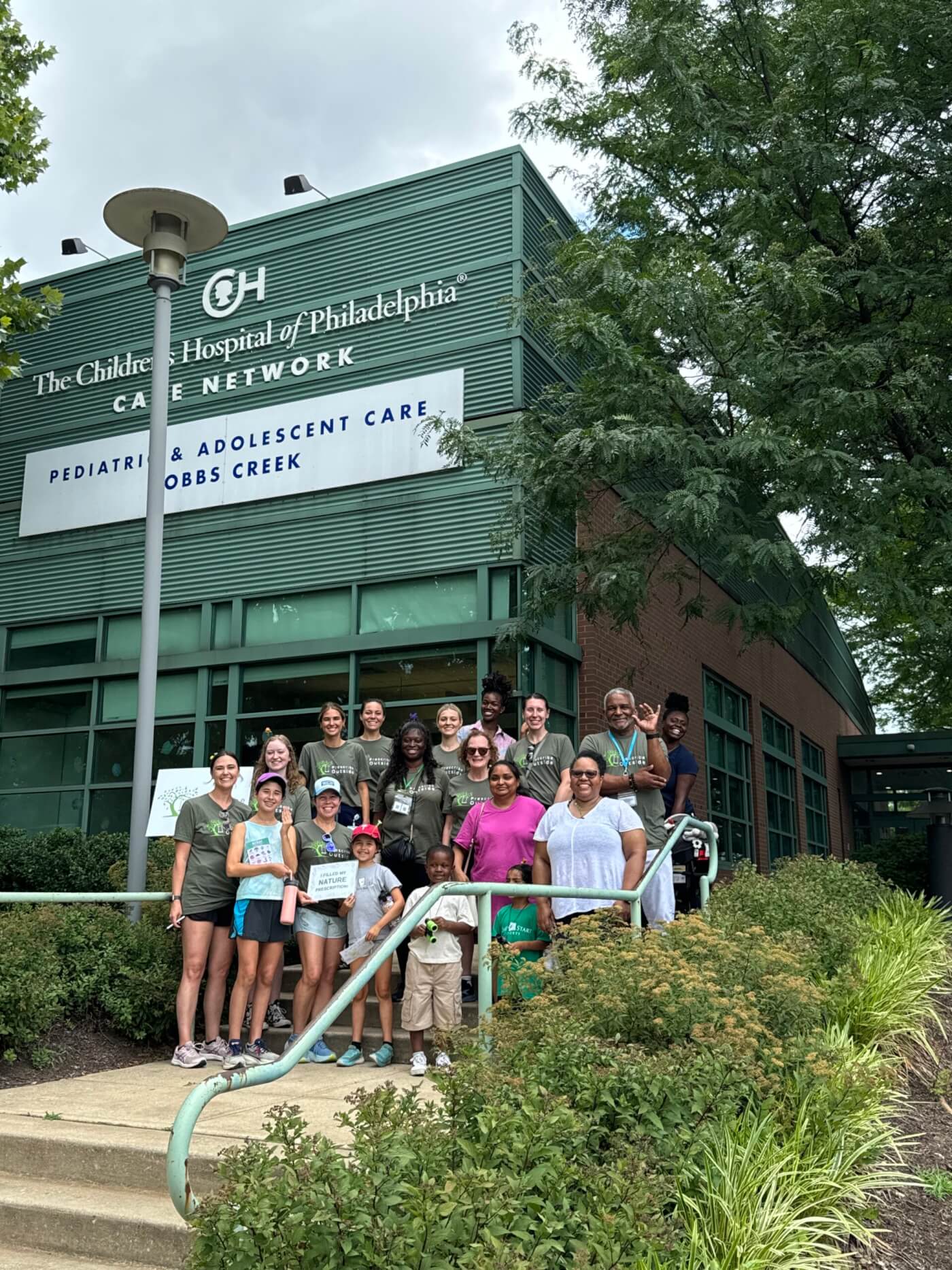 Group of adults and children posing outside a Children’s Hospital of Philadelphia building.