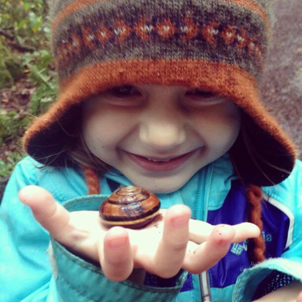 Child holding butterfly in hand.