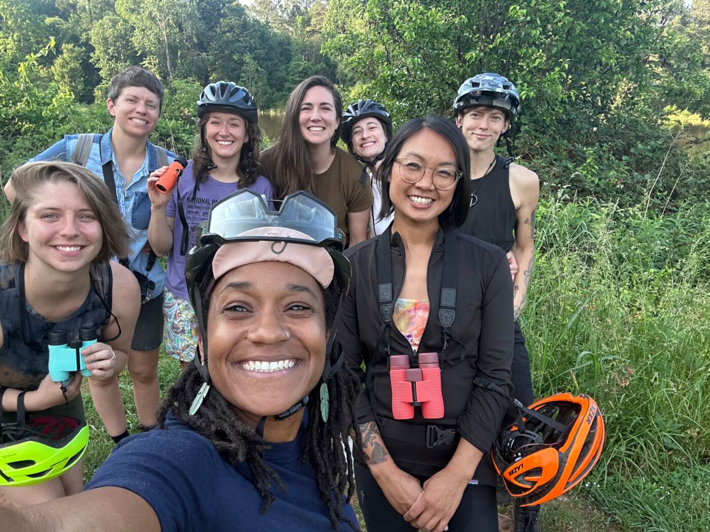 Devin takes a selfie in front of a group of seven other birders.