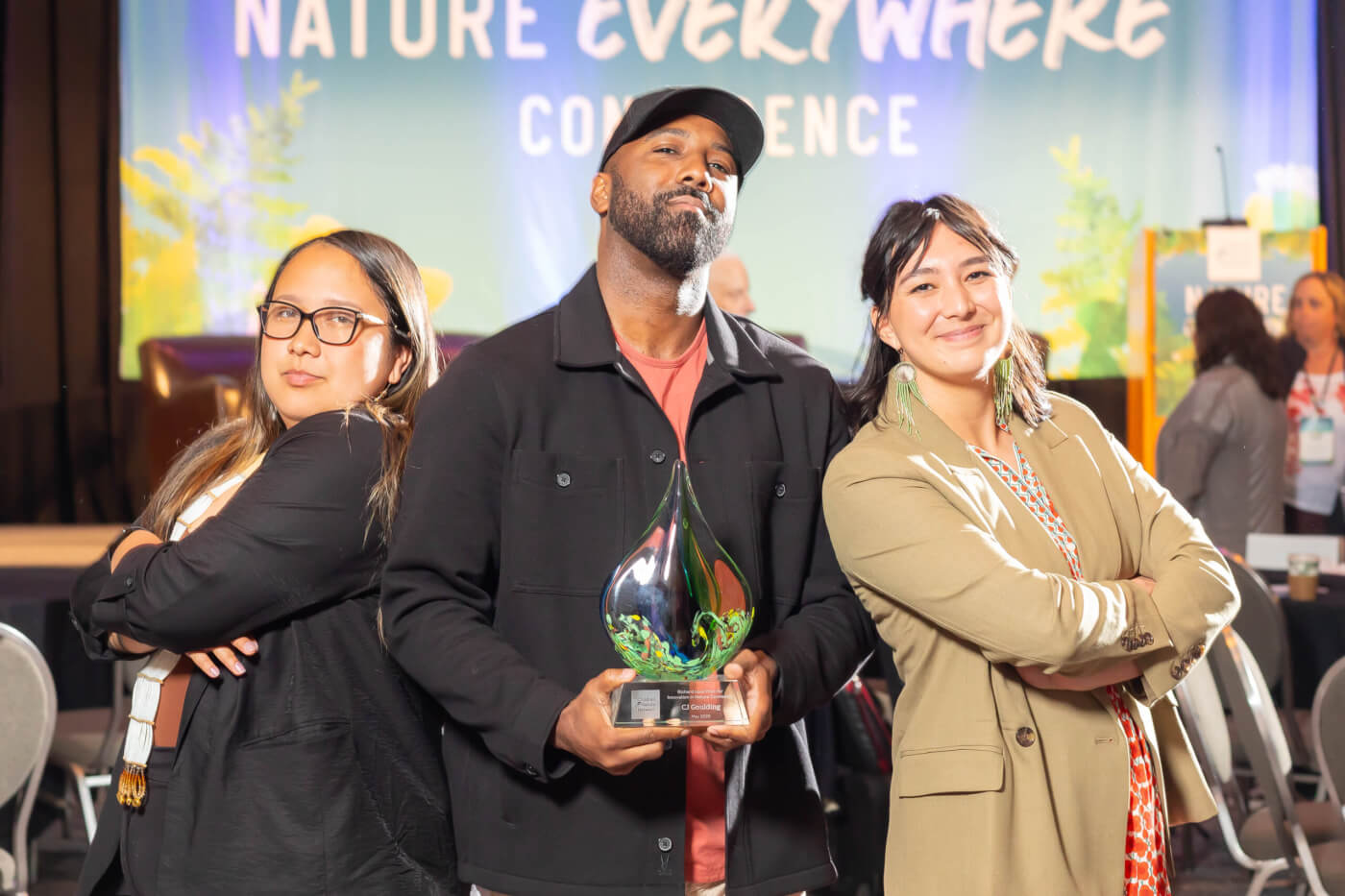 CJ Goulding strikes a pose with his Richard Louv Prize award. Andrea Wagner and Mckaylin Peters are on either side of him with their arms crossed.