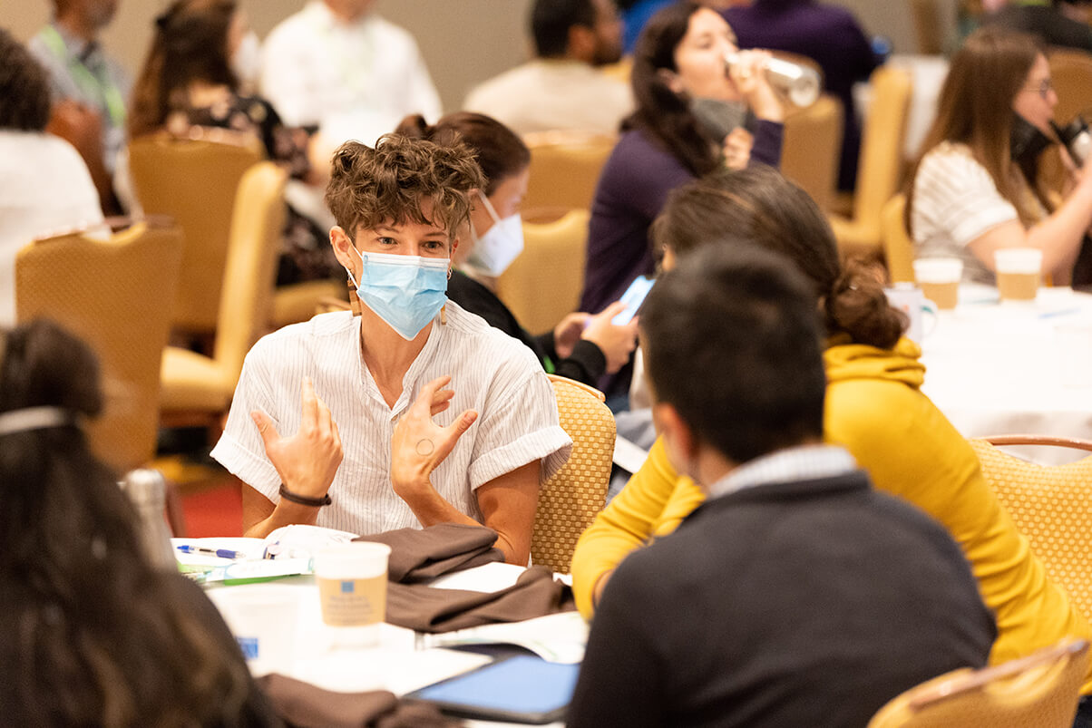 people conversing at conference tables