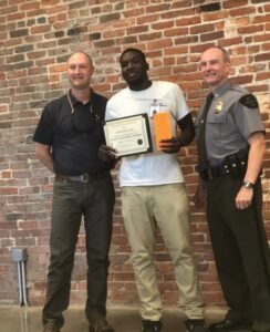 Adult posing with award.