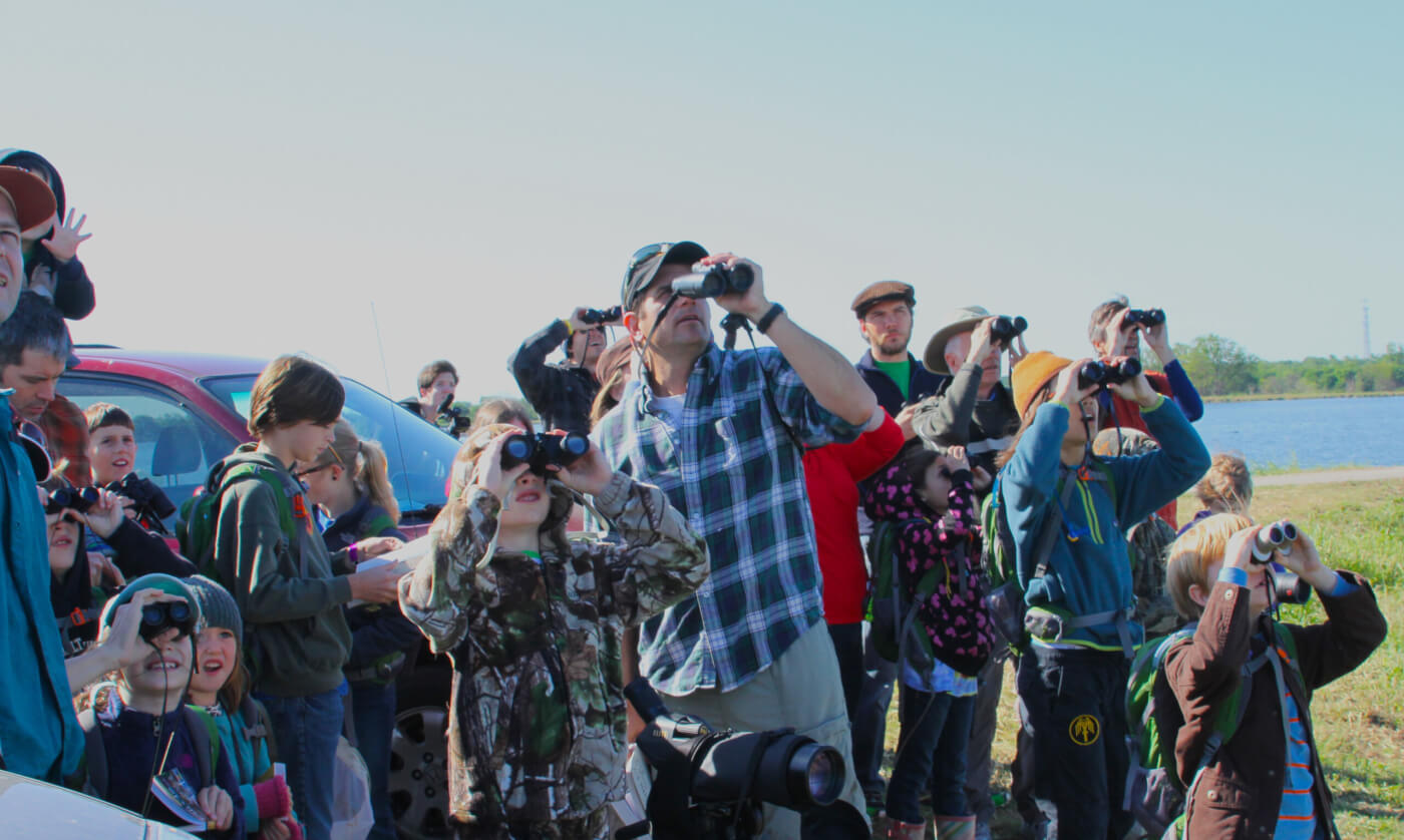 group of people looking into sky with binoculars on their faces