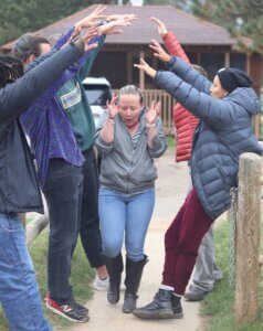 Young leaders raise their arms in celebration at the Children & Nature Network’s Legacy Camp in 2022.