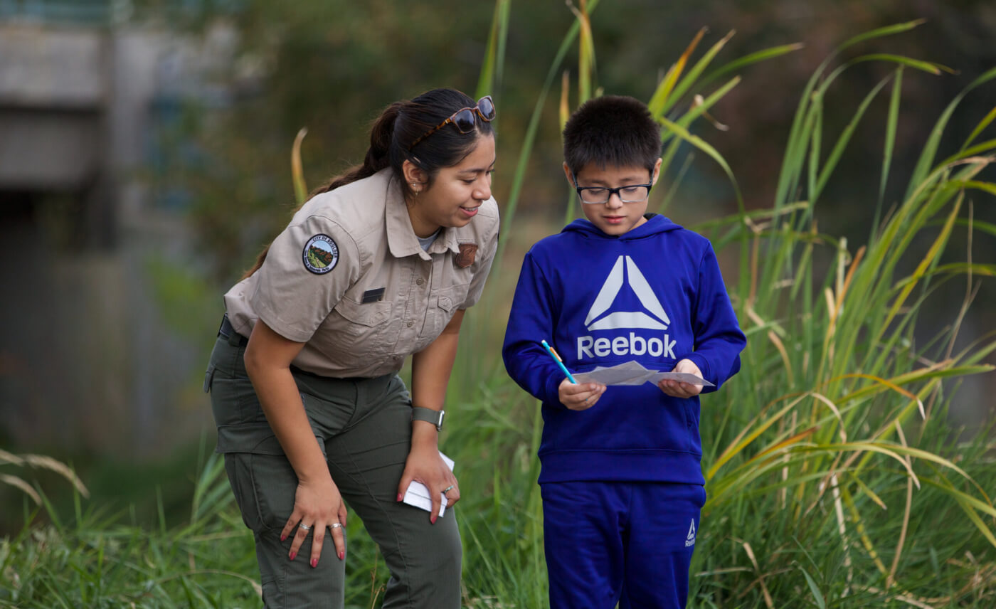 Council member Leidy Pineda Flores helps a boy connect to nature while working for Boulder, Colorado’s parks.