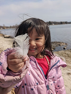 Tiffany's daughter holding a feather.