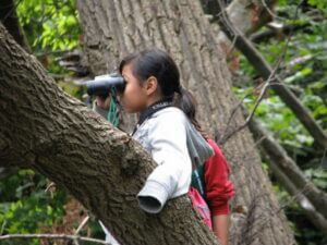 Girl looking through binoculars.