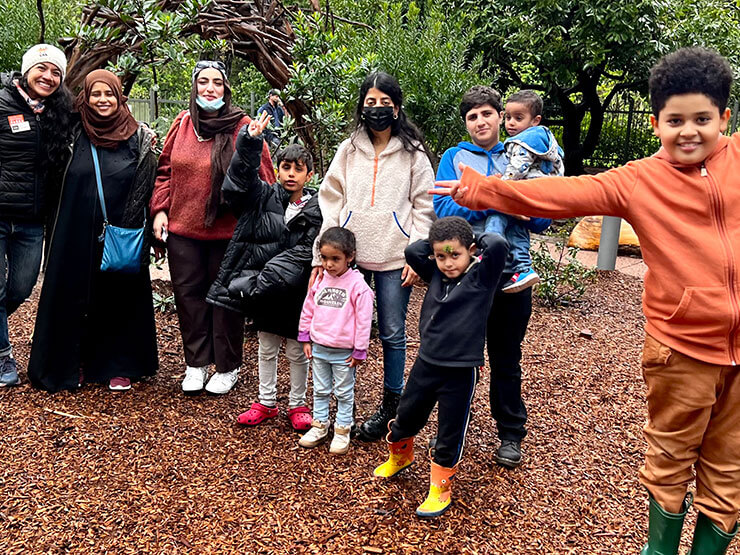 Park staff and Tenderloin families posing in nature with joy.