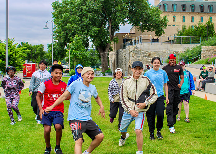 A group of teenagers smiling and posing in a park.