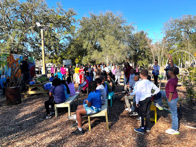 Groups sitting on various benches in an urban park.