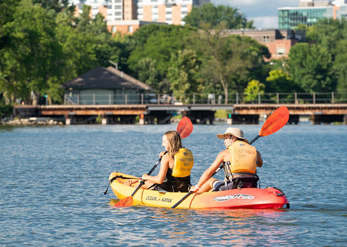 People rowing on a paddle boat in Madison, WI.