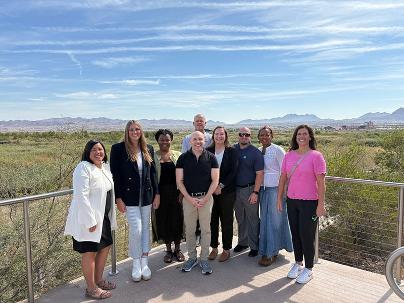 Group posing outside in Nevada with mountains behind them.