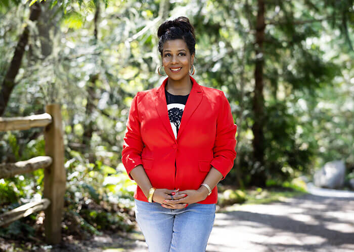 Rue Mapp posting outdoors in front of trees.