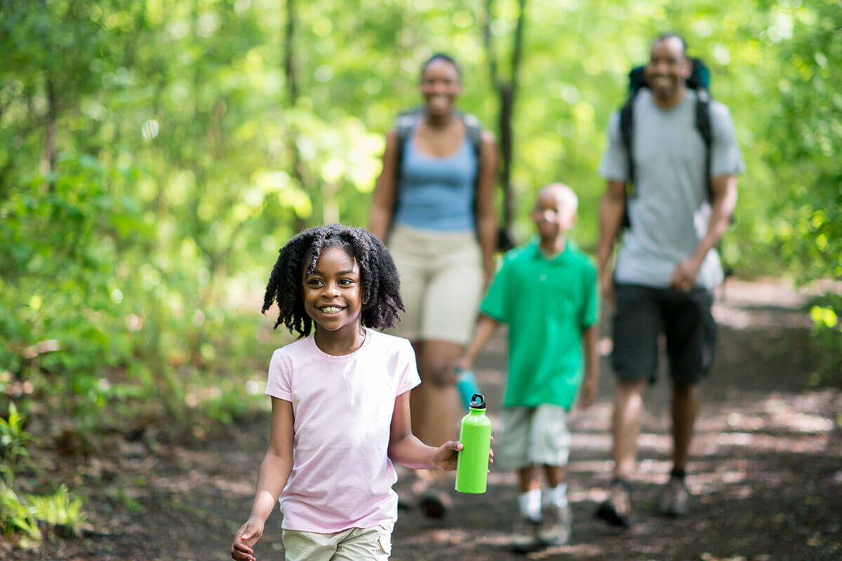Family outdoors walking in forest.