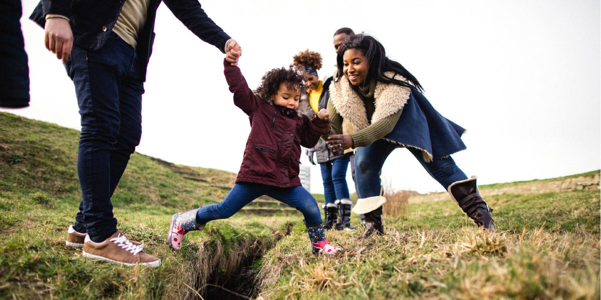 Family playing with younger daughter outside.