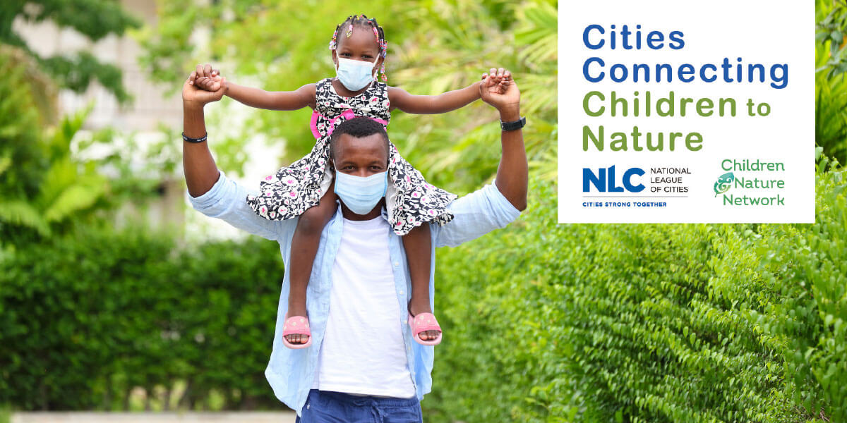 A father and daughter wearing masks outdoors.