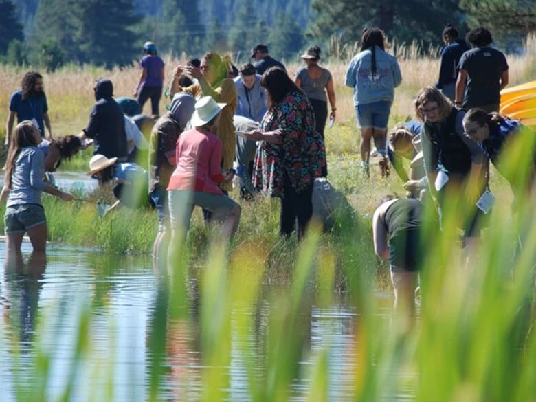 large group of people on the shore of a lake