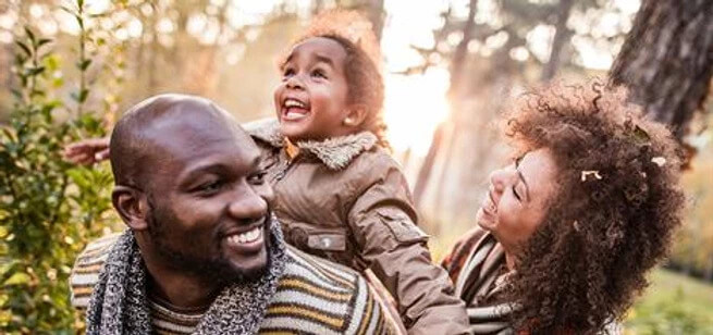 family smiling and walking in the woods