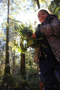 kid in forest holding plants
