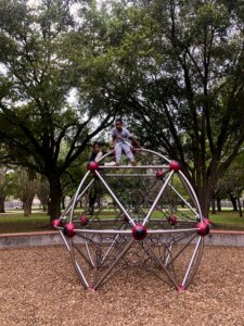 Two children climb on a jungle gym.