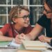 Kid studying with mom.