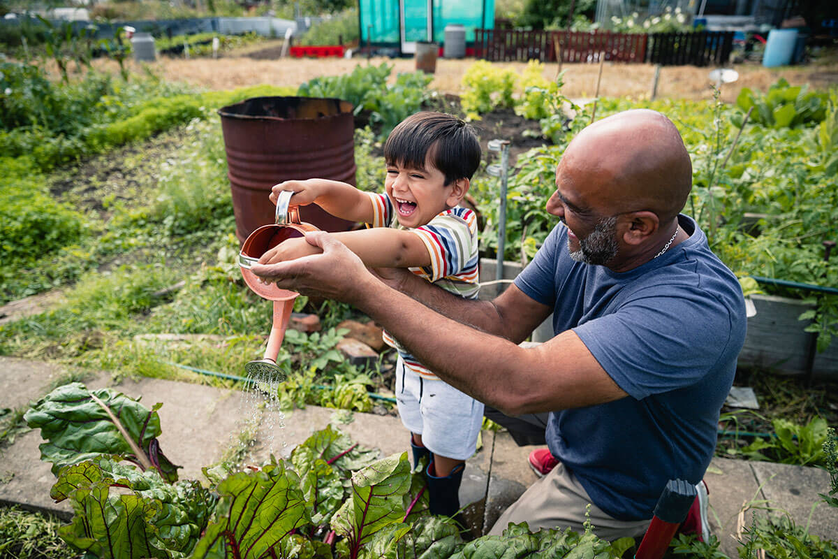Man and Boy Watering Plants