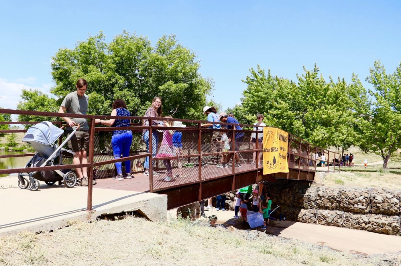 photo of people walking over a metal bridge for Nature Ninos