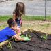 At Union Missionary Baptist Preschool, two girls help plant seedlings around the irrigation hoses. Photo courtesy of Smart Start of New Hanover County
