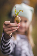 Girl holding out radish.
