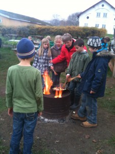 Children playing outside over bonfire.