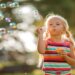 child blowing bubbles