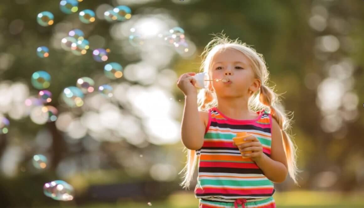 child blowing bubbles