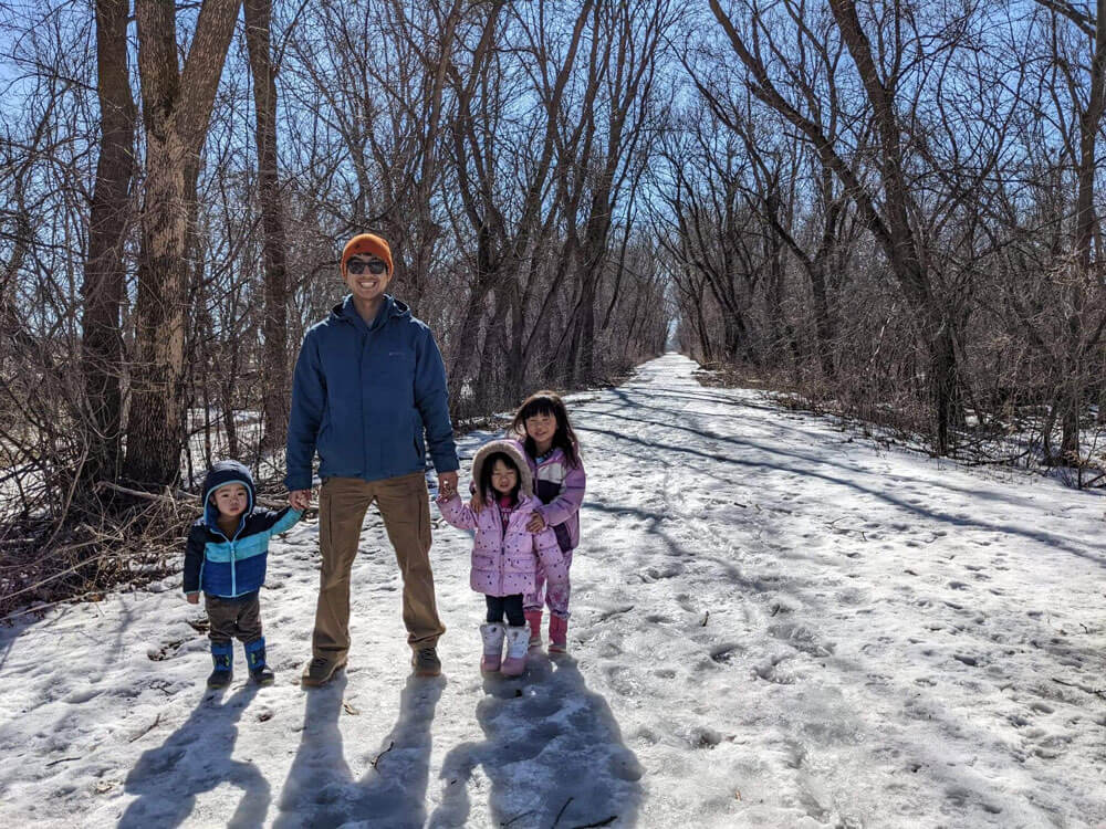 Kong and their kids in a snowy forest.